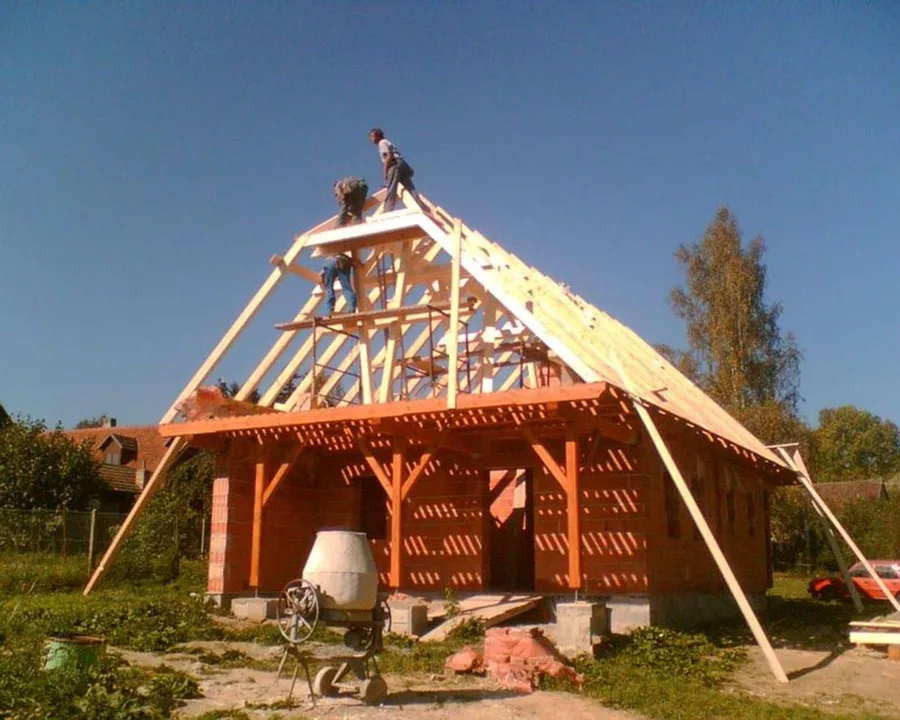 Vysoký krov nad dřevěným přístřeškem, tesař pracuje na hřebeni, Černý Les