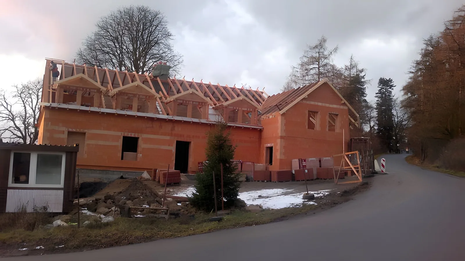 Rozestavěný krov s řadou vikýřů na zděné stavbě penzionu u silnice, Chotoviny