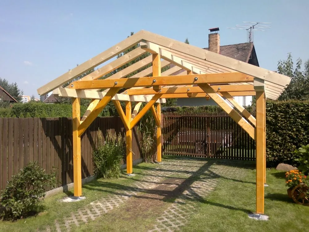Hotová dřevěná pergola na dlážděné ploše u&nbsp;domu